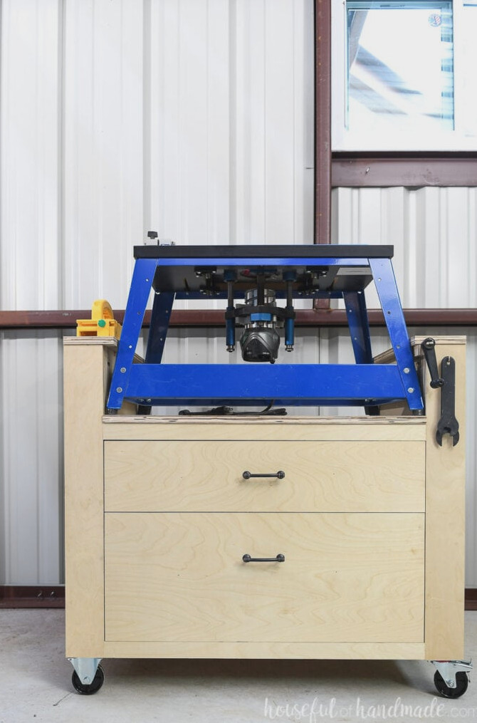 Front view of the new bench top router table with a Kreg Bench top router on top, highlighting the raised sides and a push block resting on one side.