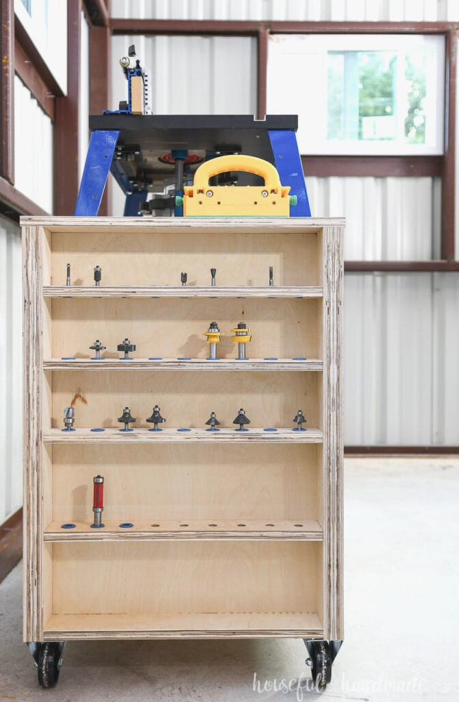 Straight-on view of the left side of the DIY bench top router table, showing shelves designed to store router bits.