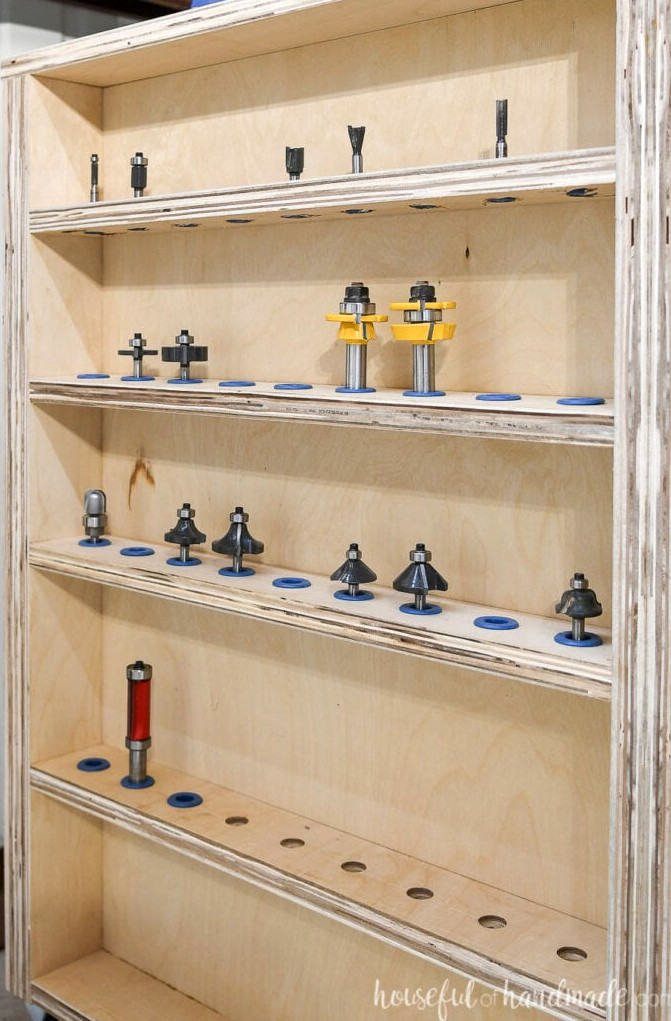 Close-up view of the router bit storage shelves along the DIY router table side, filled with router bits in Rockler router bit inserts.