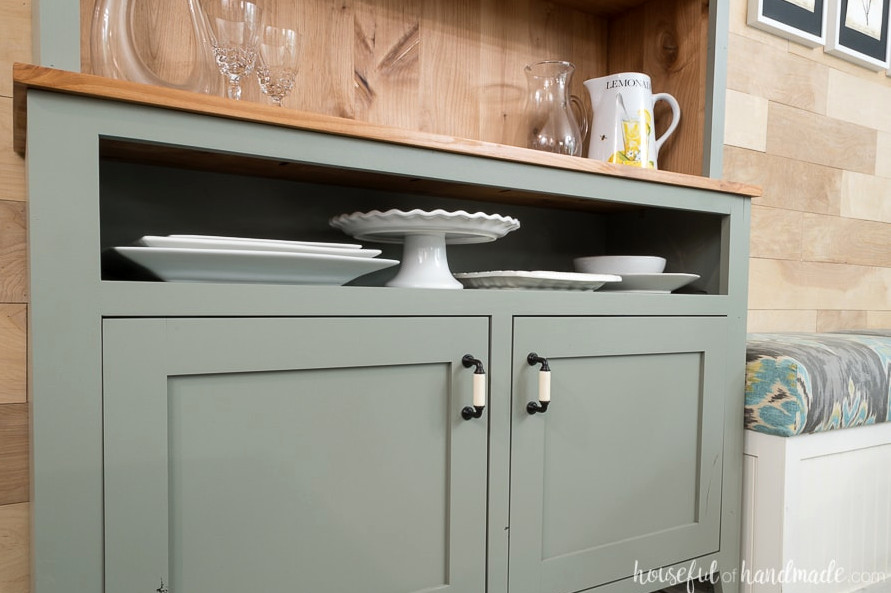 A slim open shelf at the top of the dining room hutch is ideal for displaying and storing platters.