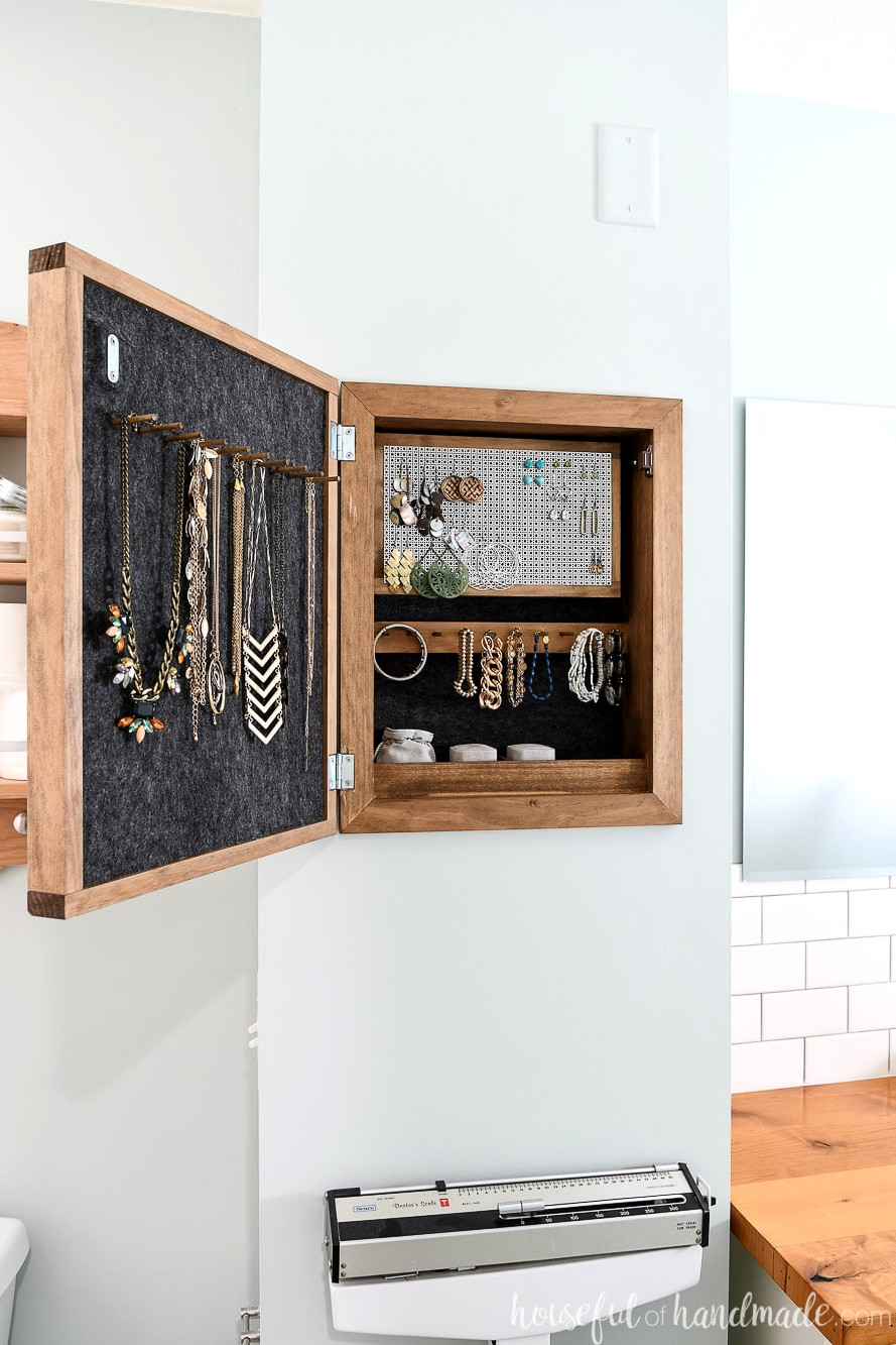 Wall jewelry organizer in the bathroom with storage for necklaces, earrings, bracelets and more.