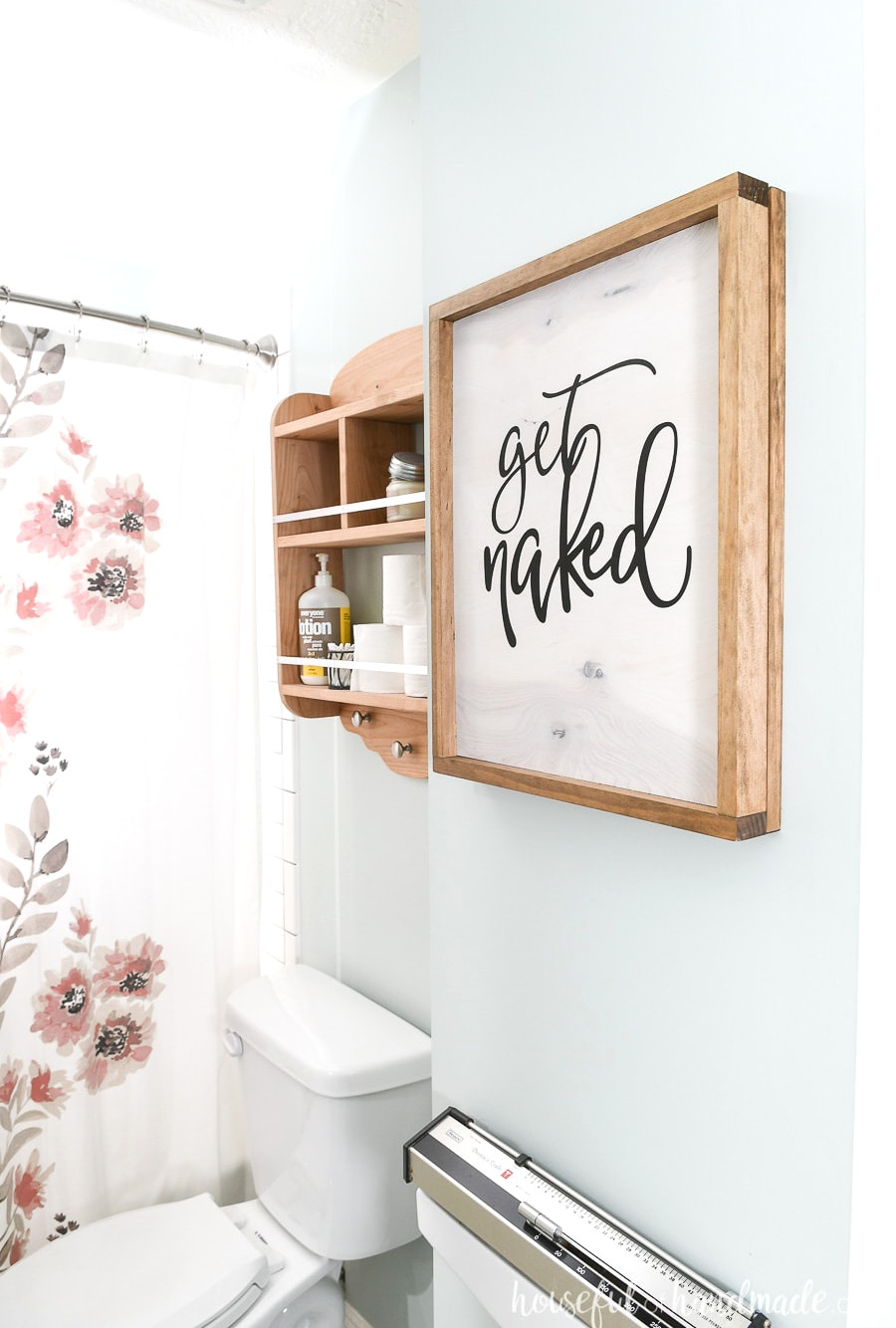 Wood sign in the bathroom hiding the wall jewelry cabinet. 