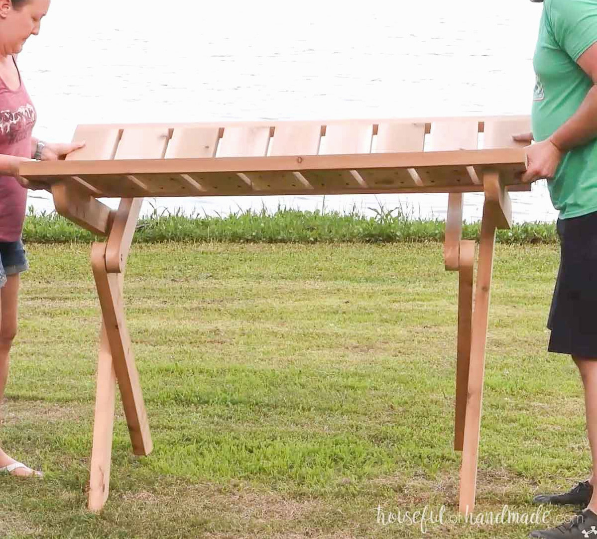 Two people collapsing the picnic table.