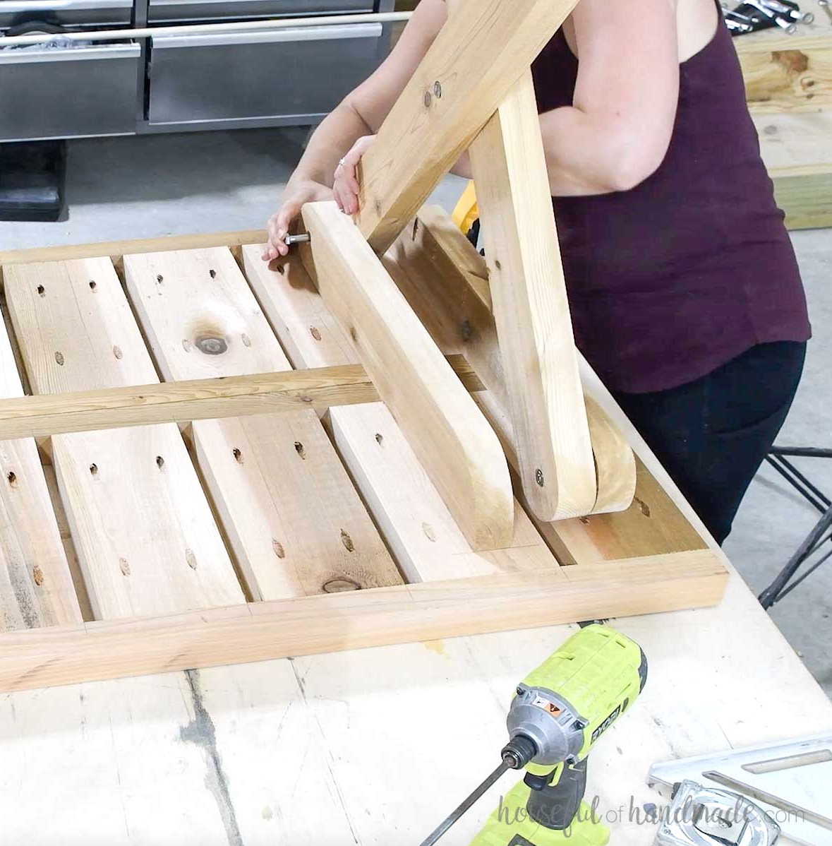 Bolting the legs to the picnic table top with nuts and washers.