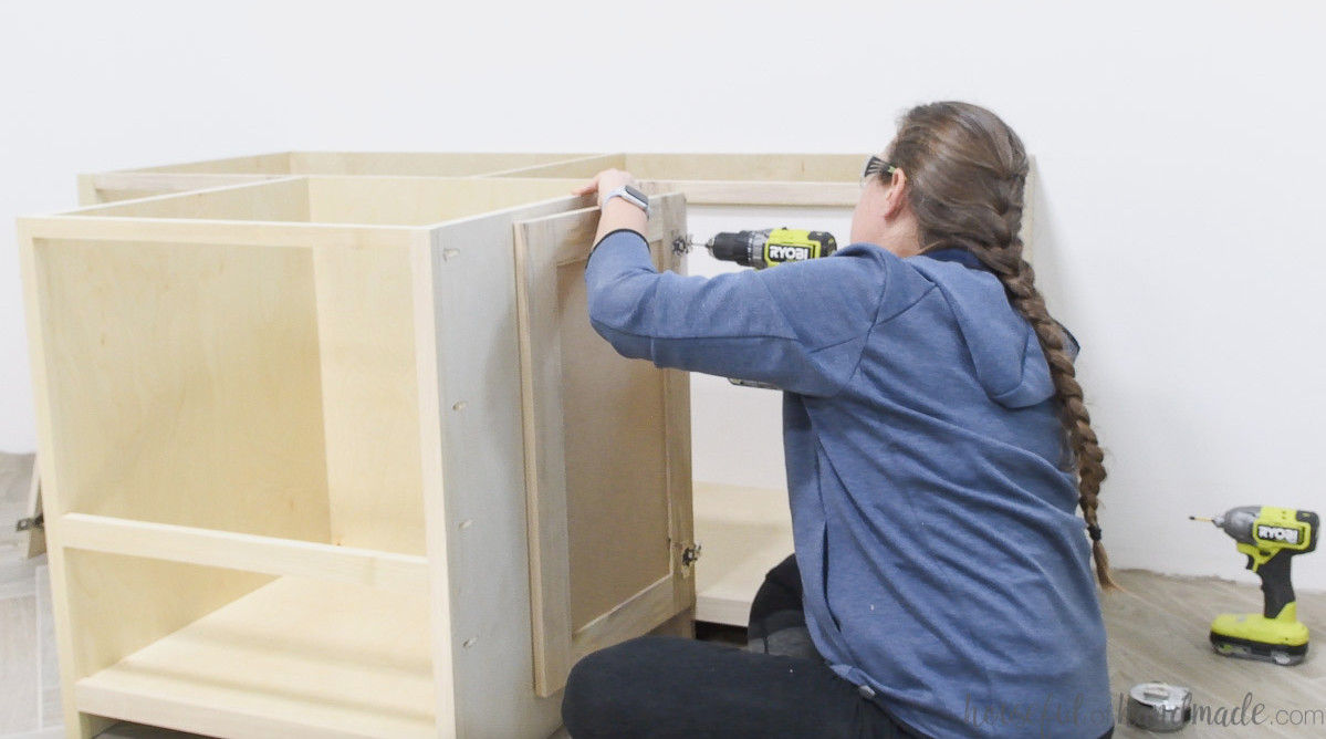 Installing a cabinet door in the DIY built in desk with concealed hinges.
