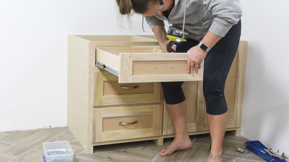 Attaching the drawer front to the drawer box with screws from the inside.
