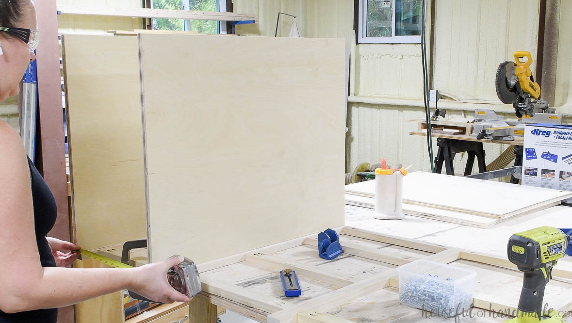Measuring the space between the two sides for the cabinet bottom panel.