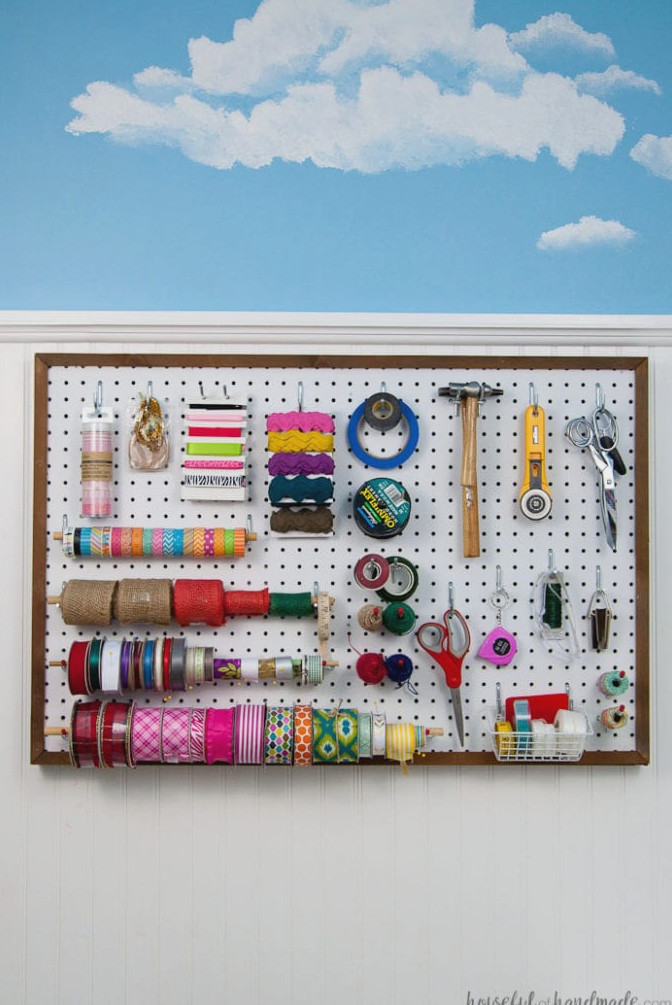Create the perfect place to organize your most used supplies! Learn how to hang pegboard so it is removable if needed. Housefulofhandmade.com | Craft organization ideas | Craft room remodel | Pegboard organization | $100 Room Challenge | Easy woodworking | Easy building plans | Free Building plans 