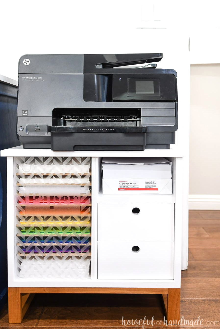 Compact white printer stand with a wooden base. Multiple shelves for storing paper and 2 drawers.