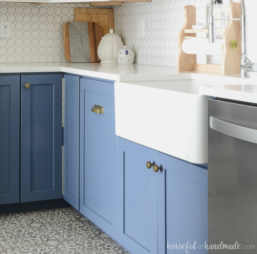 White farmhouse sink fitted into a DIY farmhouse sink base cabinet painted blue. 