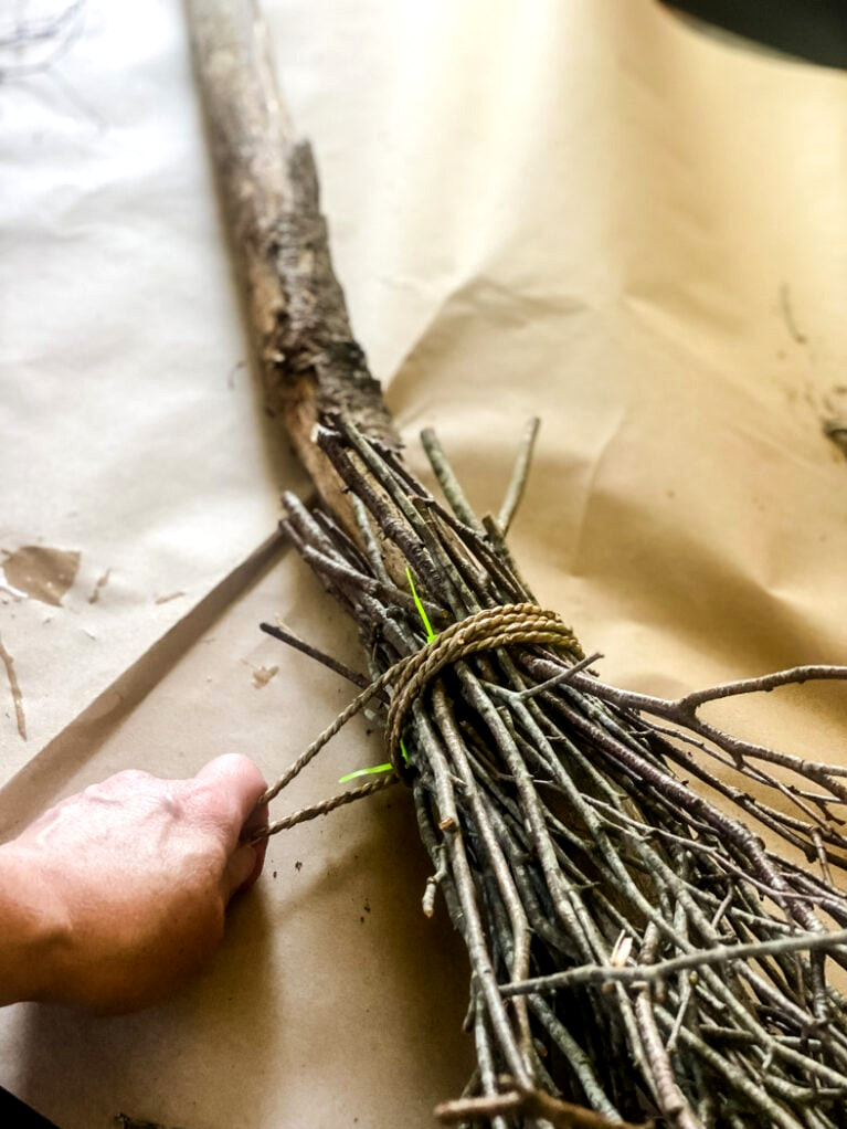 wrapping twine around a witch broom.
