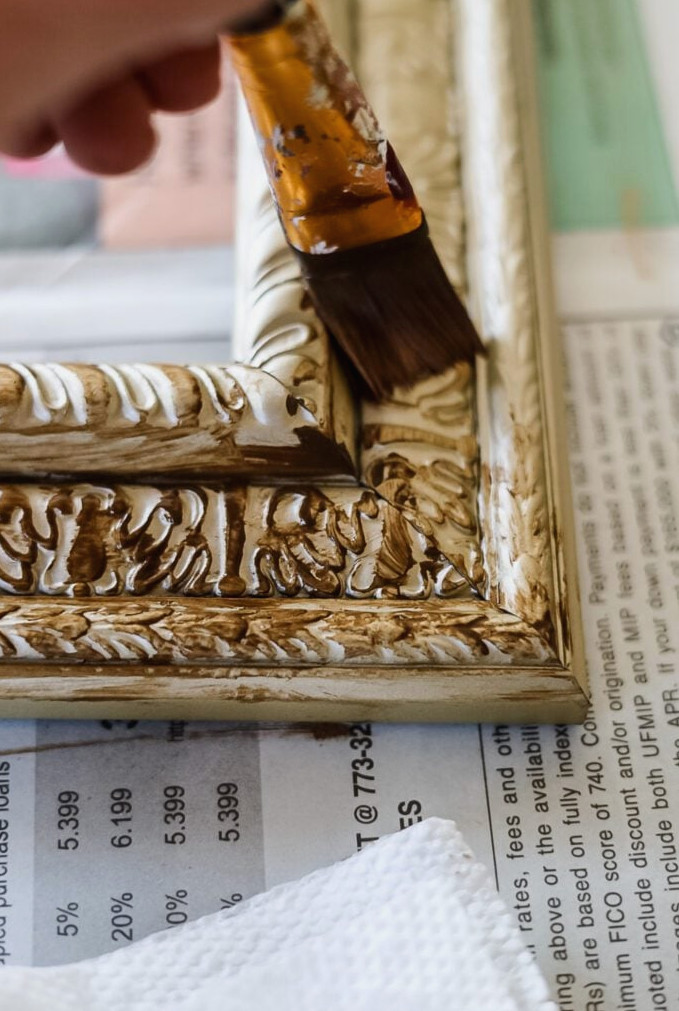 brushing antique wax onto gold frame