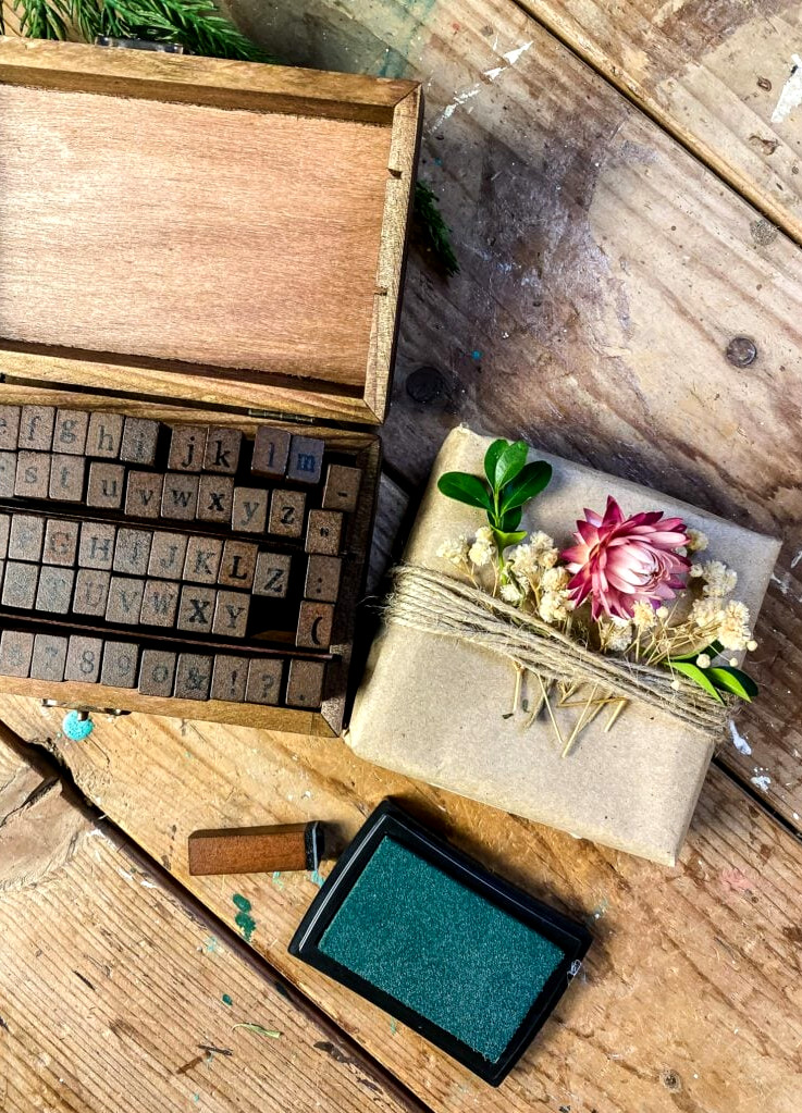 stamps and paper wrapped box with dried flowers