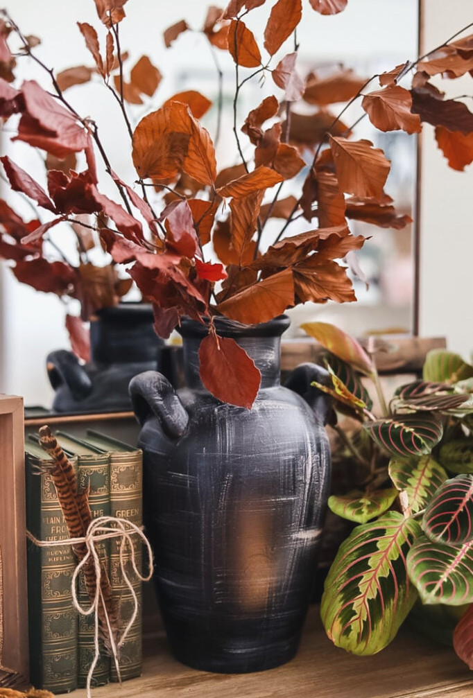 dried leaf branches in a black vase