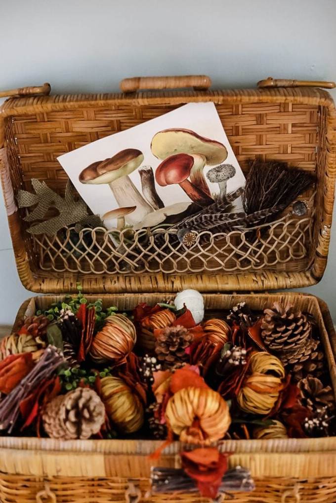 picnic basket filled with Fall items like pinecones and feathers