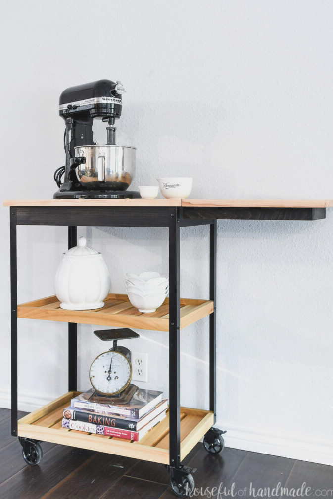 DIY kitchen cart on wheels with a raised drop-down leaf and two storage shelves. 