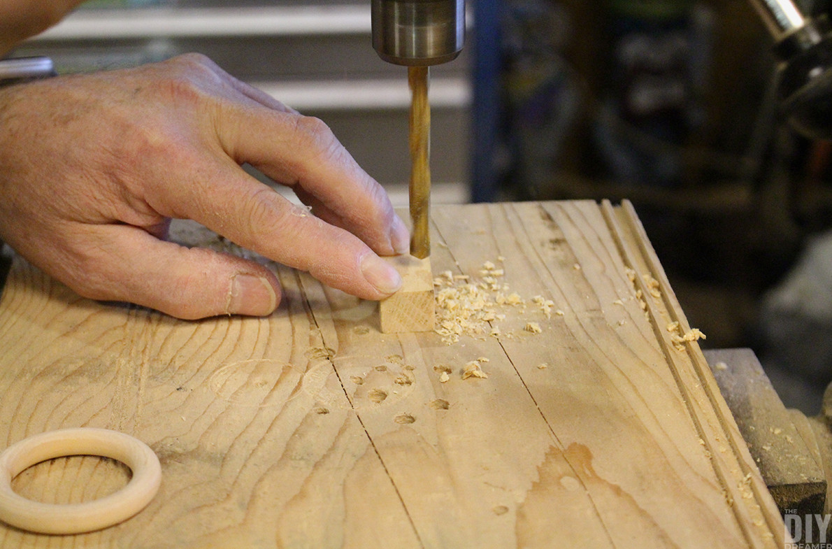 Drilling a hole into the bottom of a small wooden piece.