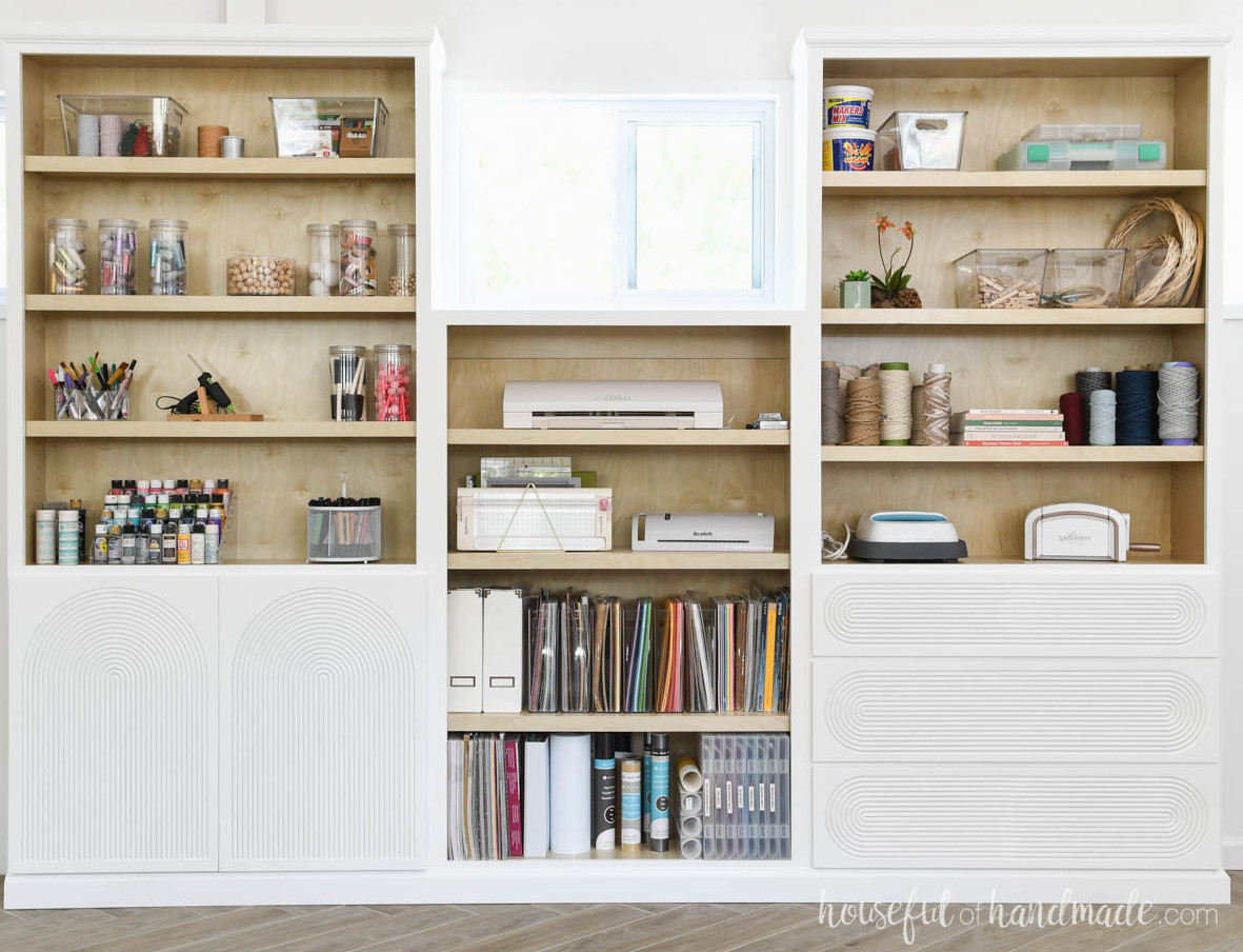 Two tall bookcases built in with a shorter one between them.