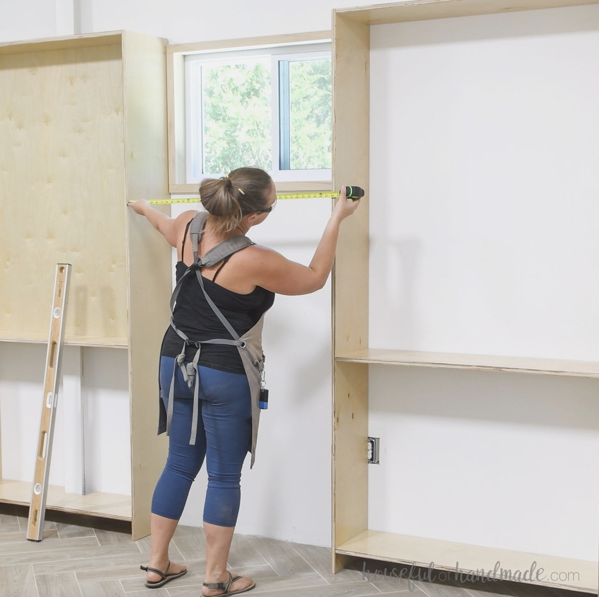 Taking measurements for the center bookcase between the assembled outer units. 