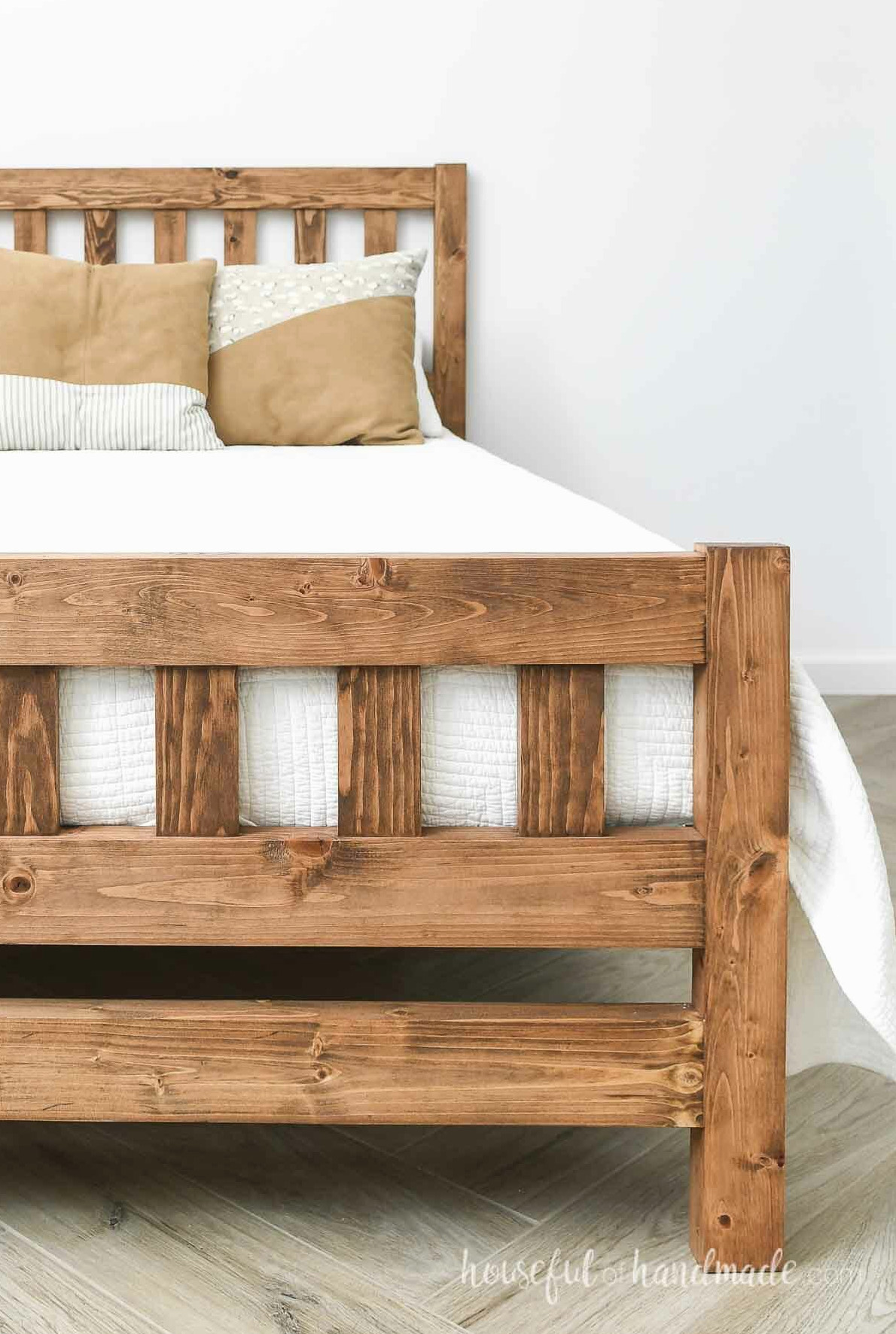 Finished wood bed with simple slatted headboard and footboard. 