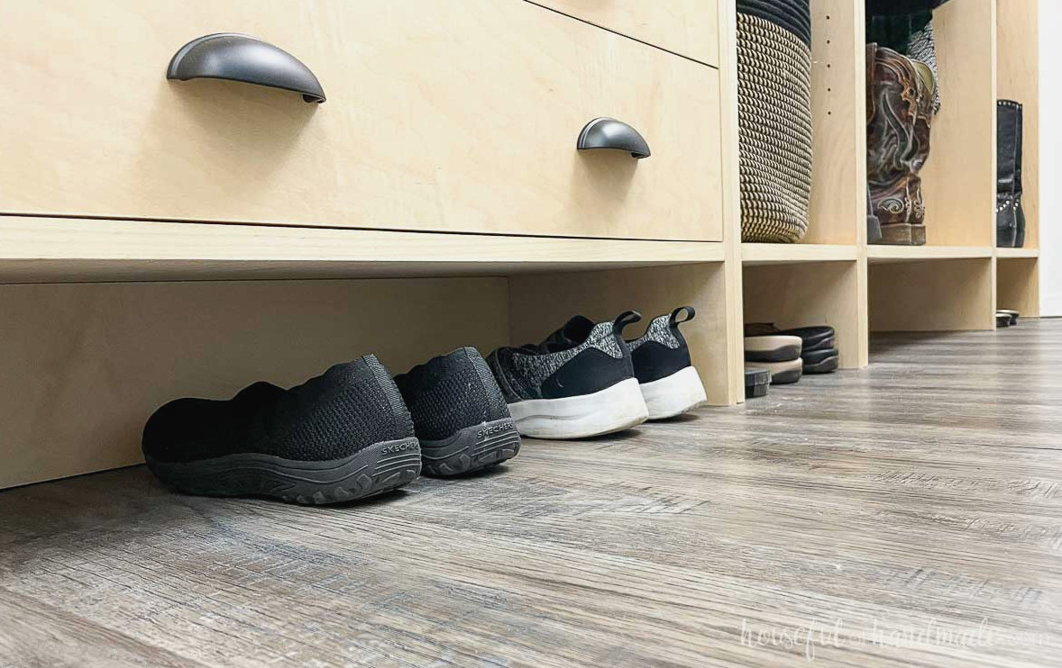 Shoe storage in the toe kick of the closet cabinets.