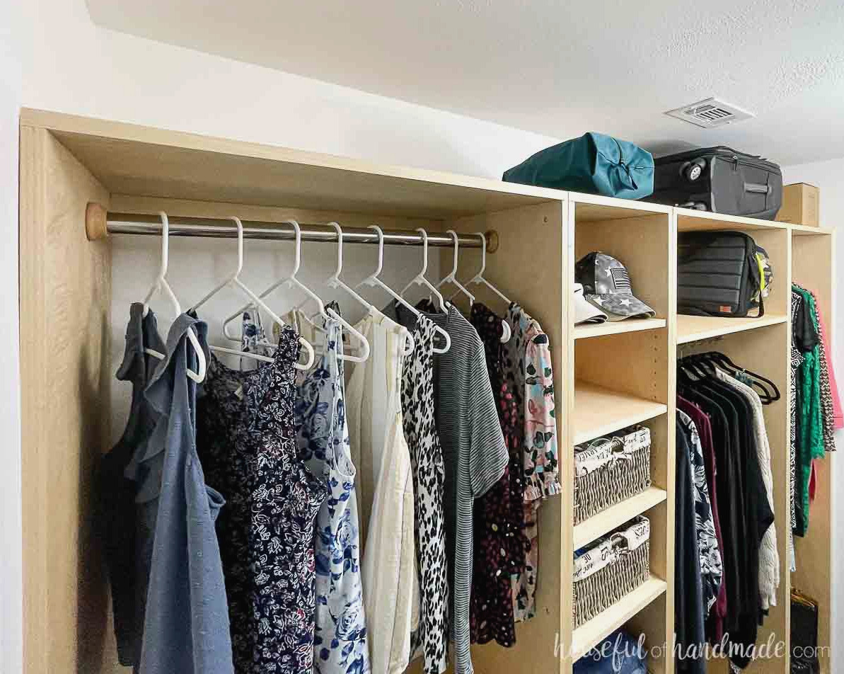 The top shelf of the DIY closet system with luggage and long tern storage in it.