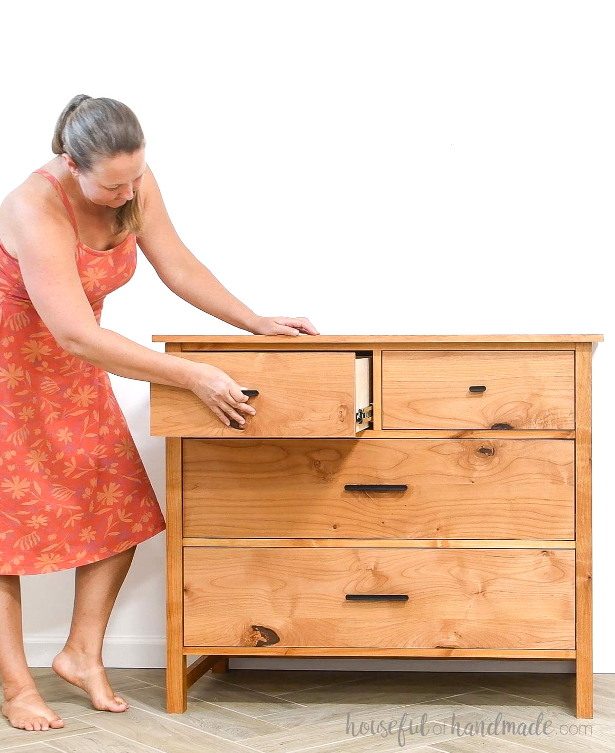 Kati opening one of the top drawers of the DIY 4 drawer dresser.