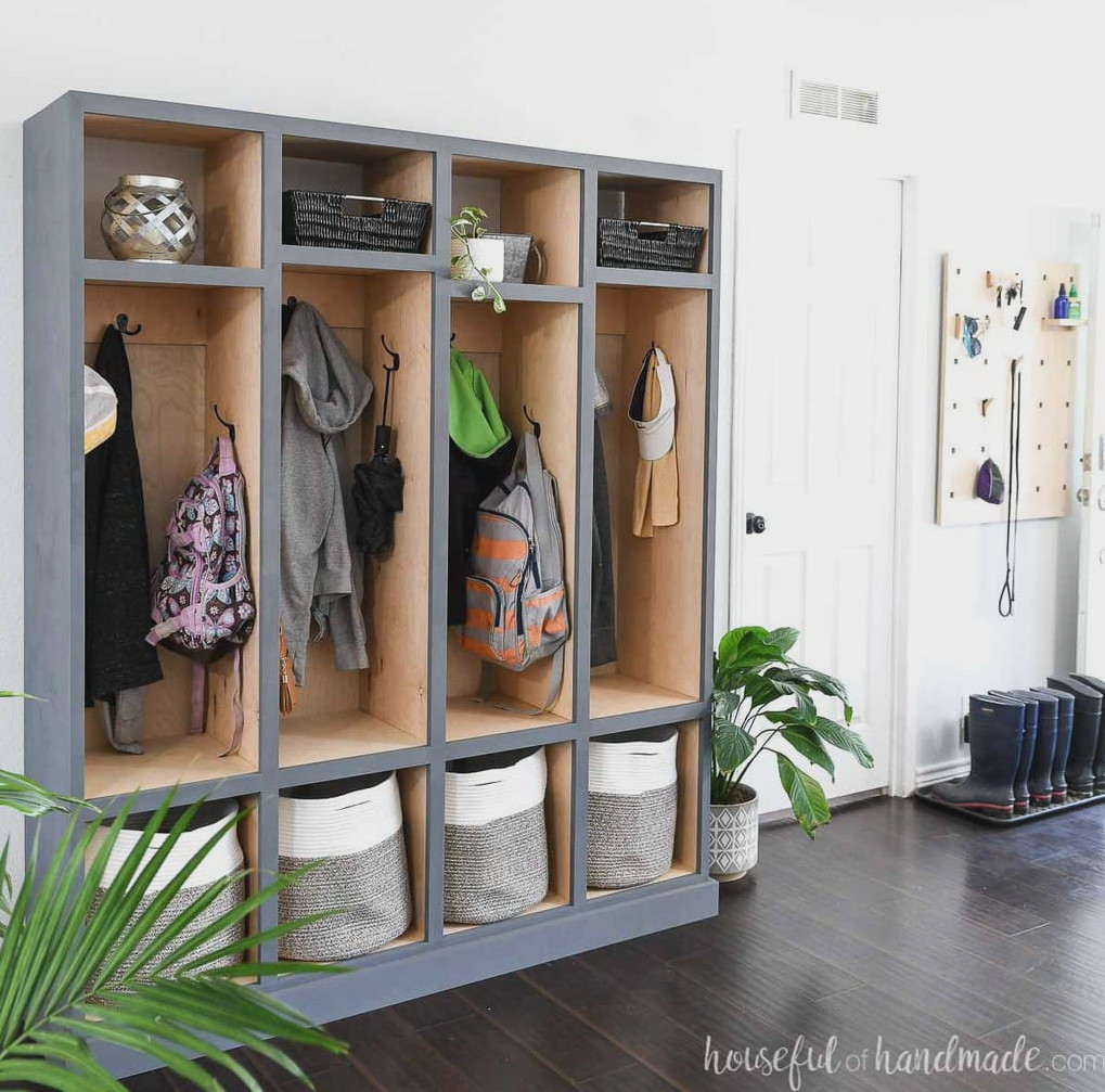 DIY storage cabinet with 4 locker sections for storing coats, shoes, backpacks, and more in a room with white walls and dark wood floors.