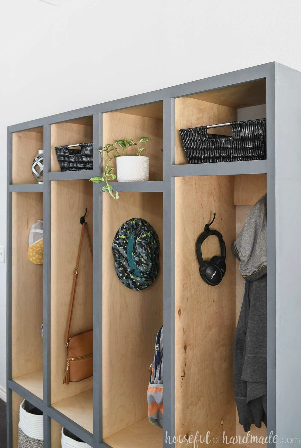 Close up of the upper shelves in the mudroom storage lockers with storage baskets and decor in them.