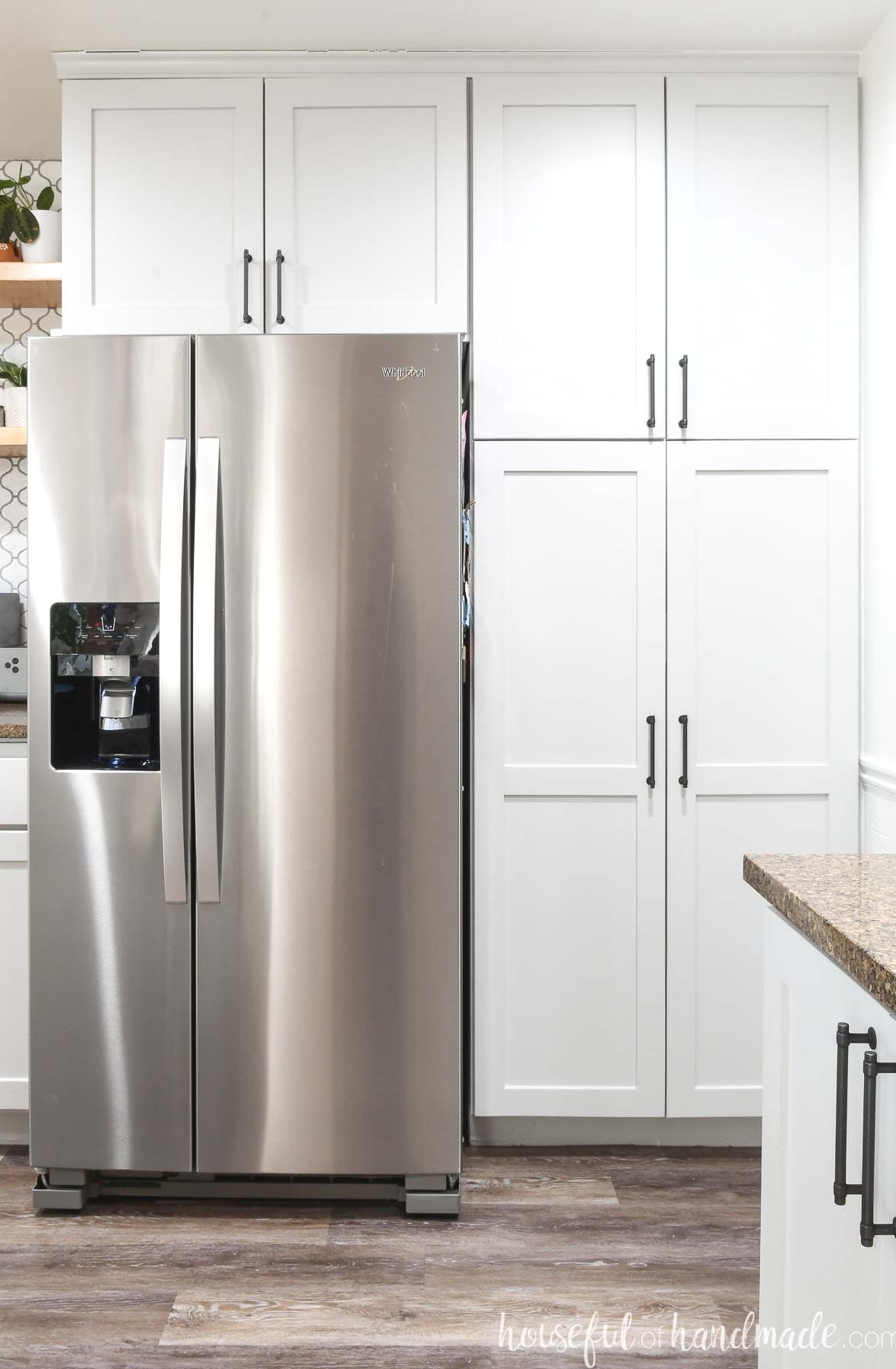 Pantry cabinets in a kitchen surrounding the fridge.