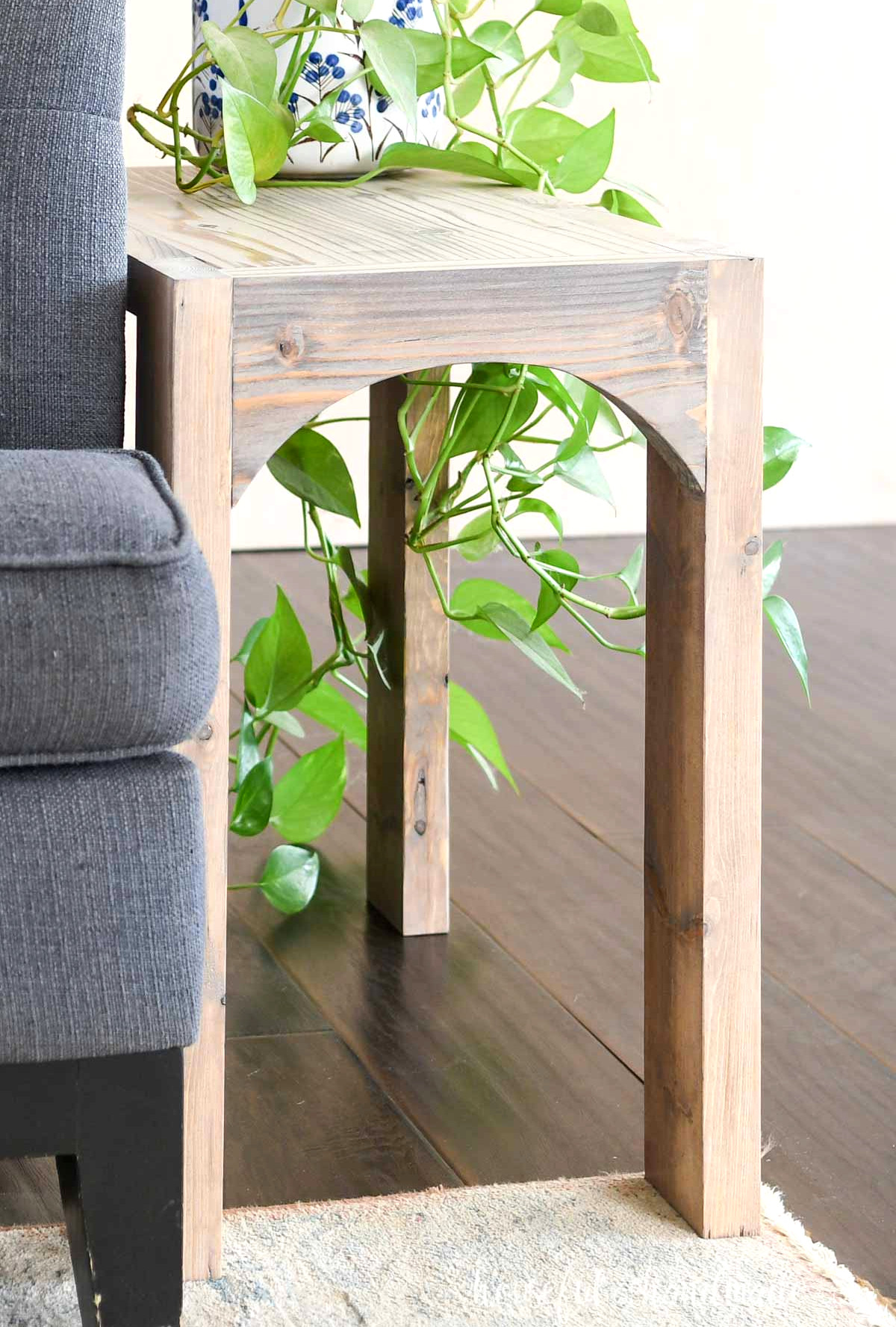 Basic side table with thick legs, a flat surface, and an arch between the front legs. 