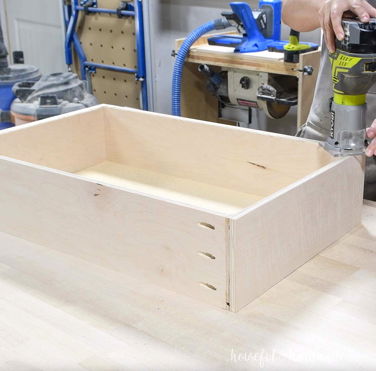 Smoothing the inside drawer-box edge with a trim router.