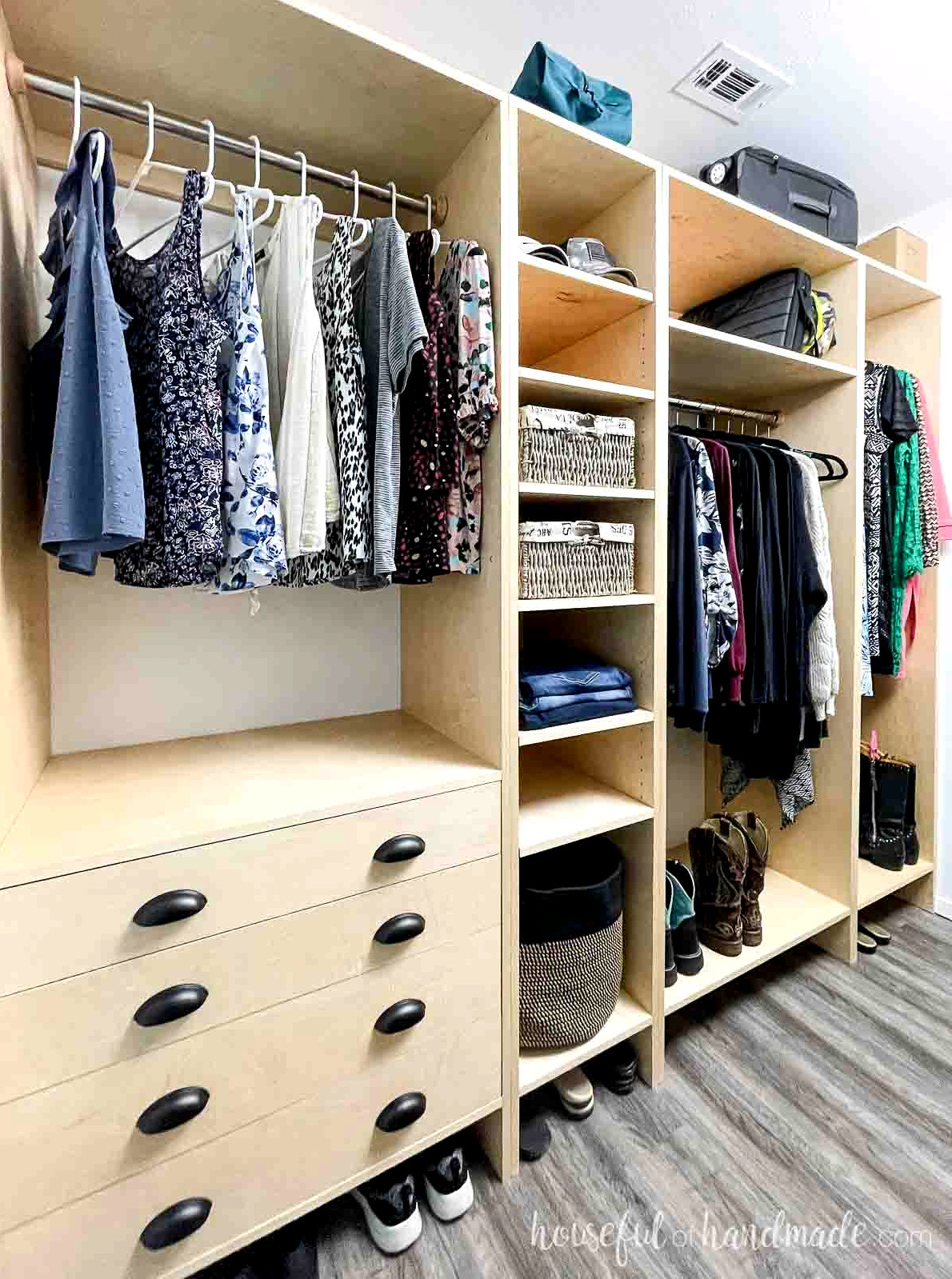 8' long DIY closet built from plywood with drawers, lots of shelves, and plenty of hanging storage.