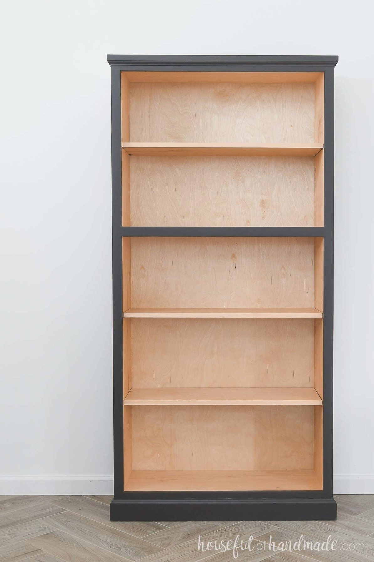 Empty DIY bookshelf with black trim and moulding.