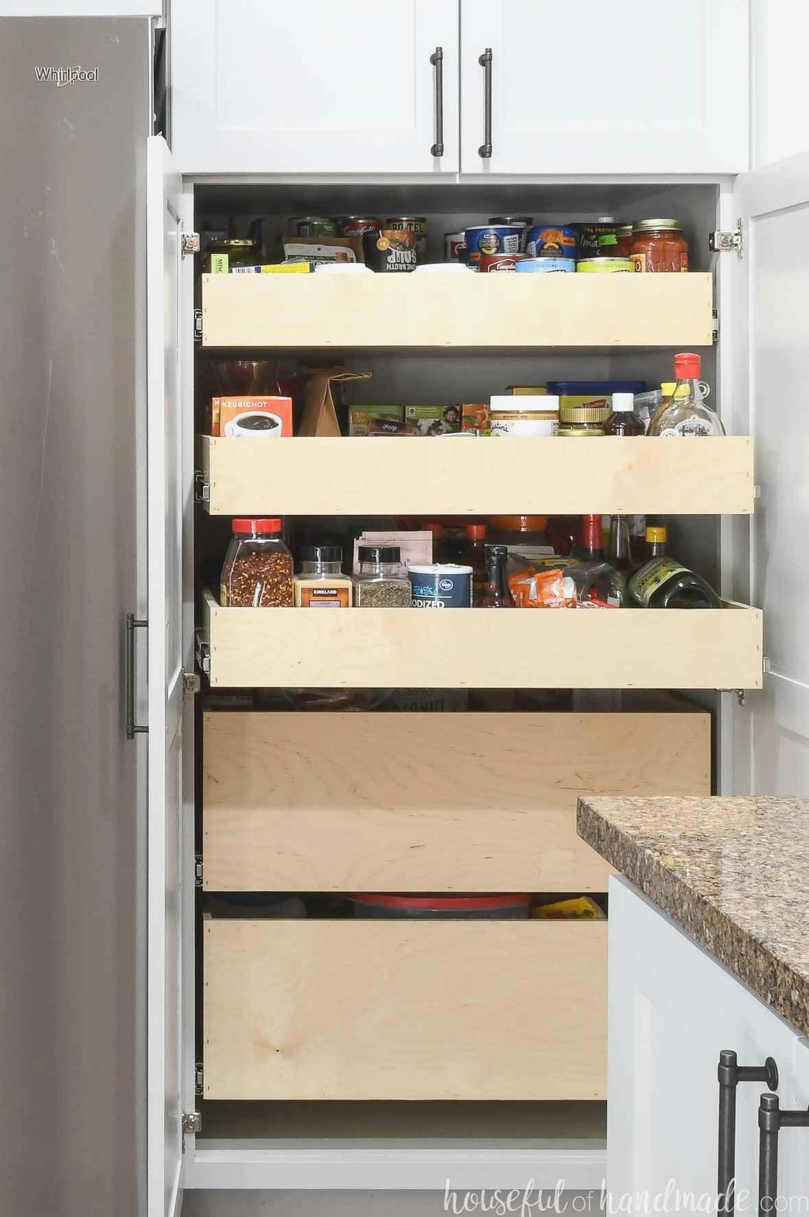 Three shallow pantry drawers above 2 deep pantry drawers in a 2 door pantry cabinet.