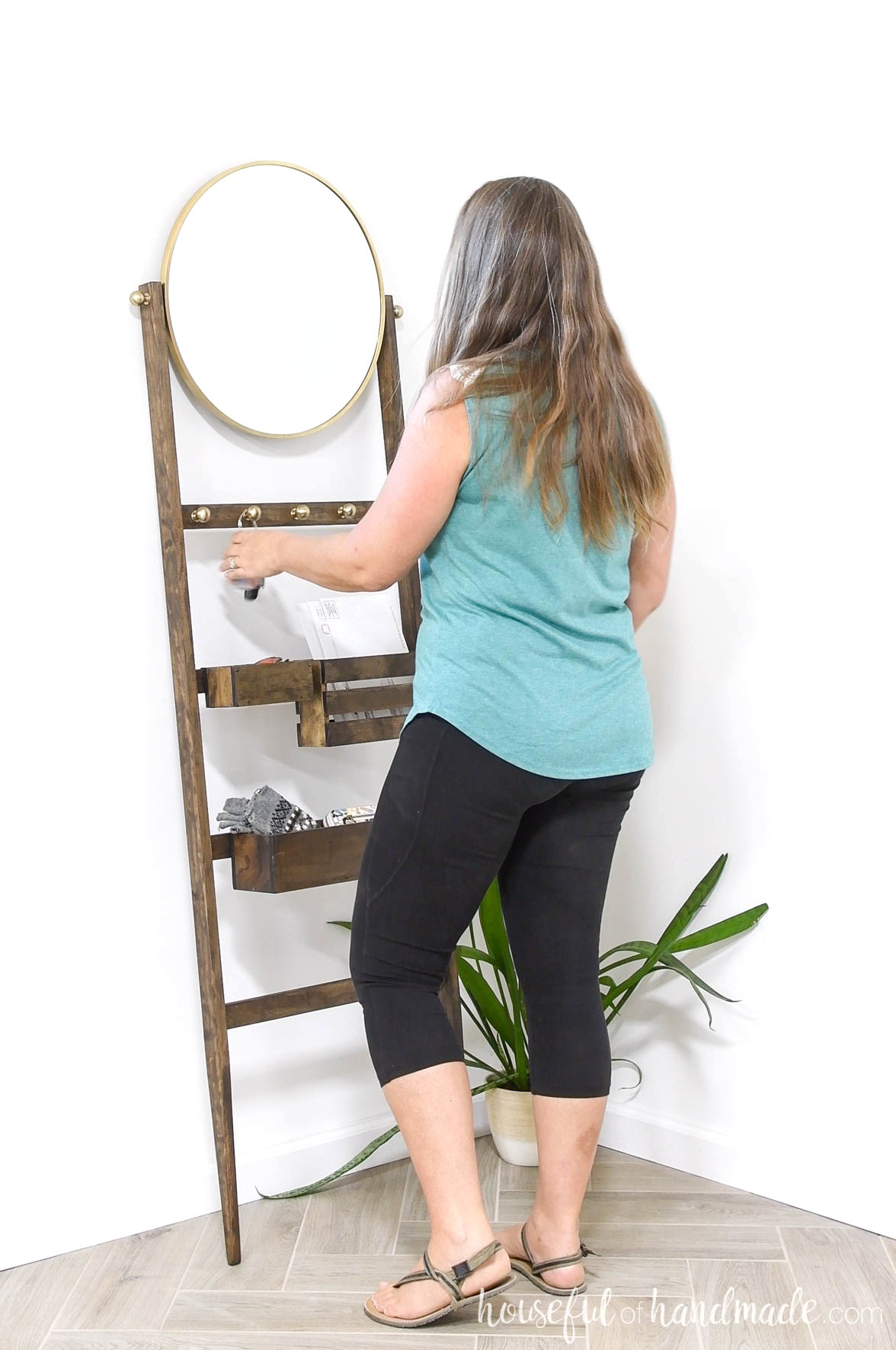 Kati standing at entry storage ladder looking in mirror.