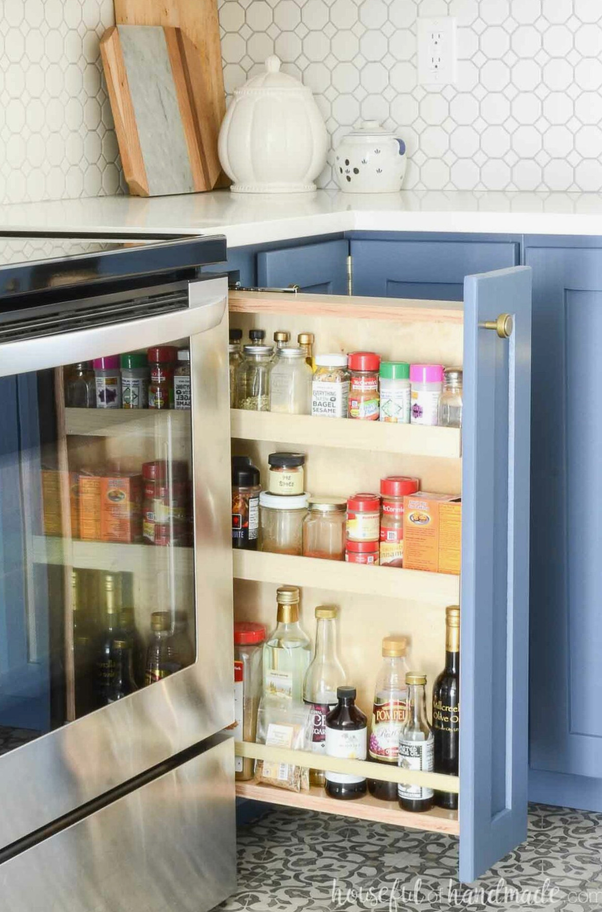 Pull-out spice rack cabinet beside a stove.