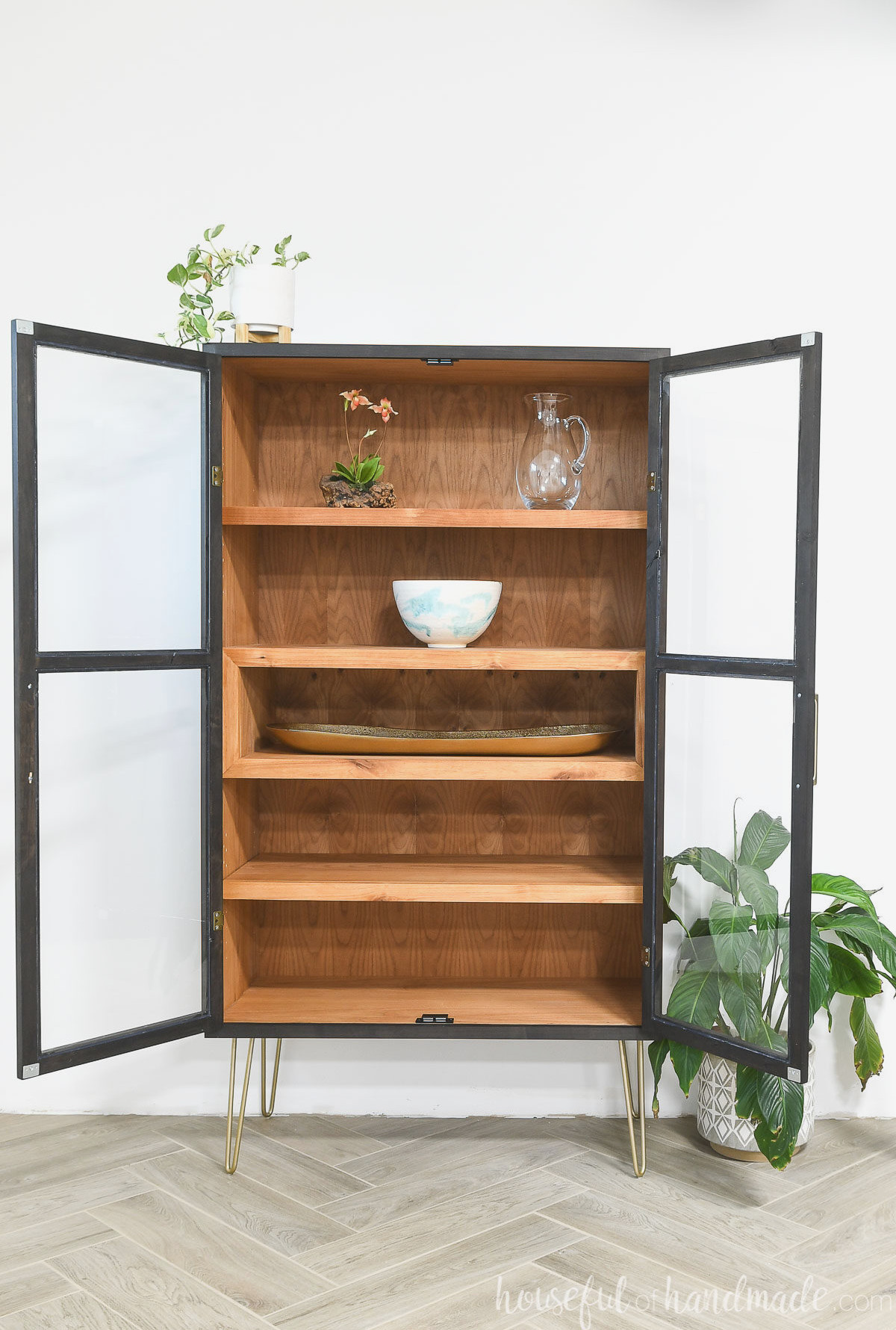 DIY curio cabinet with two open glass front doors and 4 shelves inside.