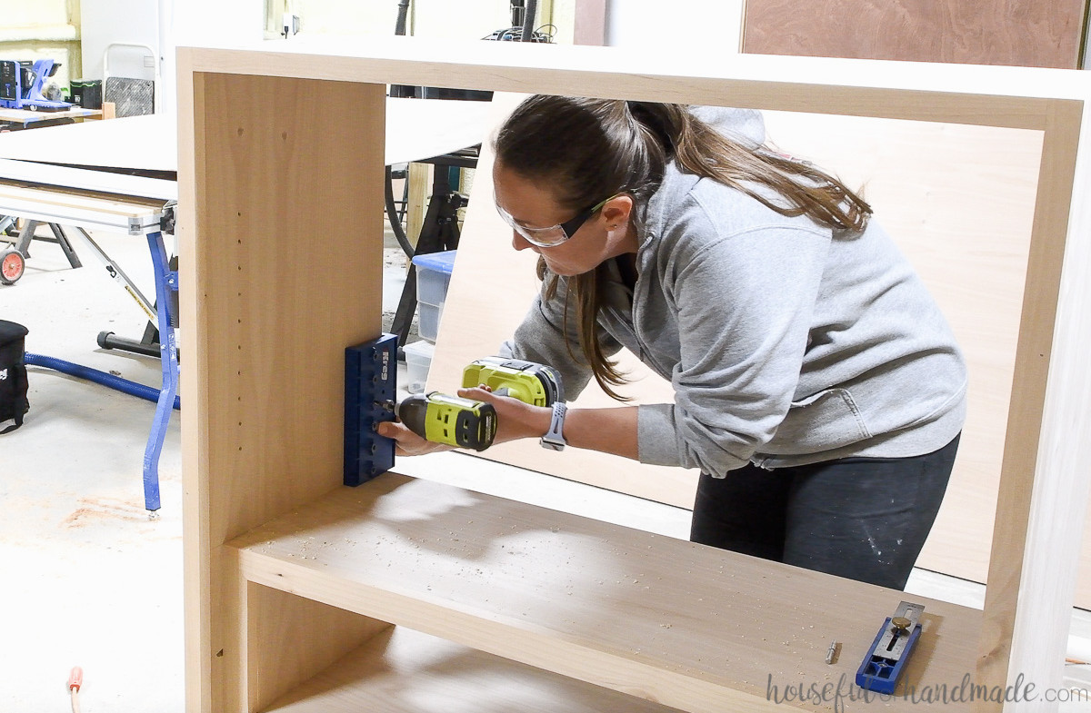 Installing shelf-pin holes inside the DIY display cabinet.