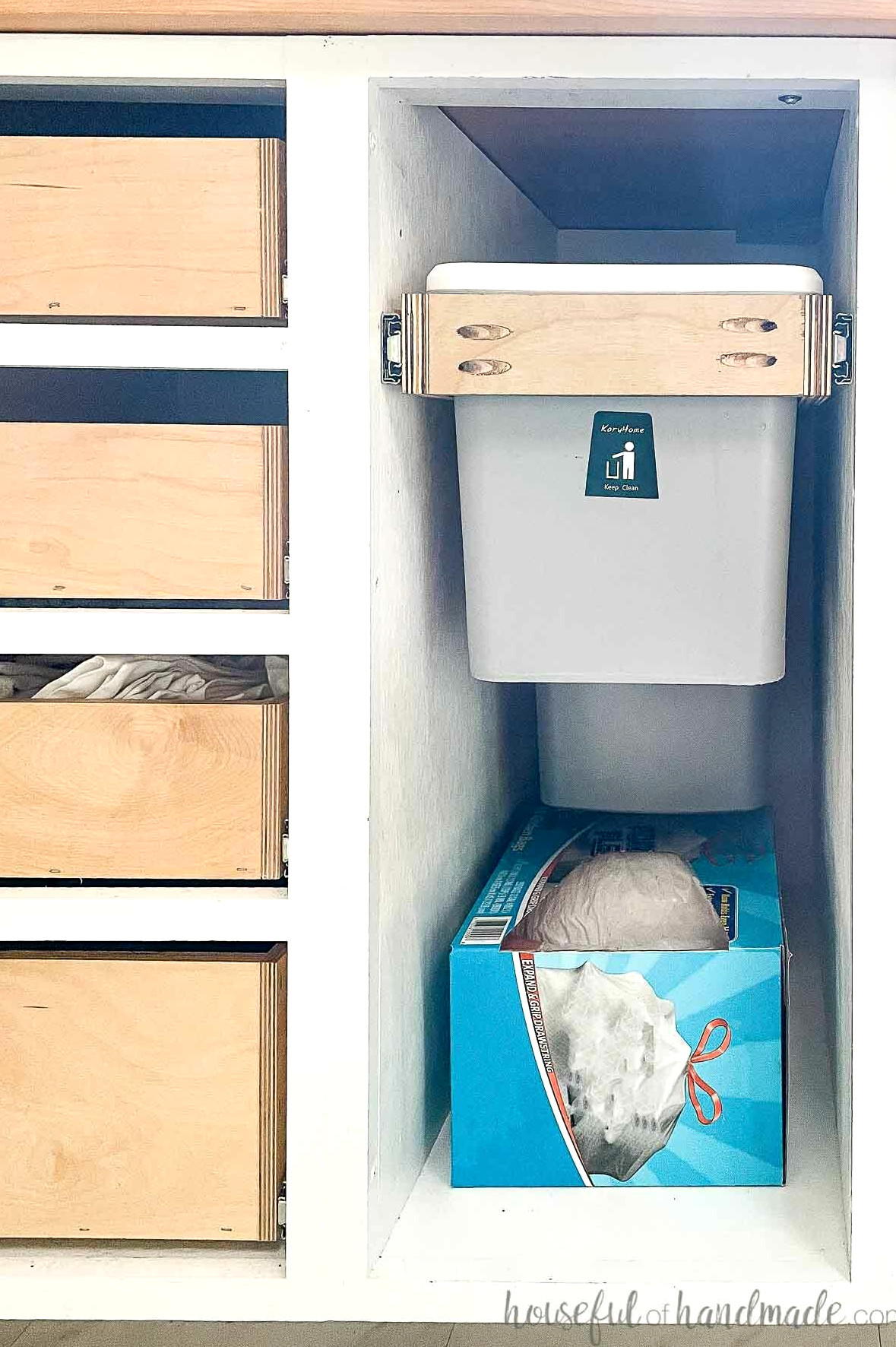 DIY kitchen renovation featuring a garbage can cabinet with a trash can and compost bin, plus space below for a box of trash bags.