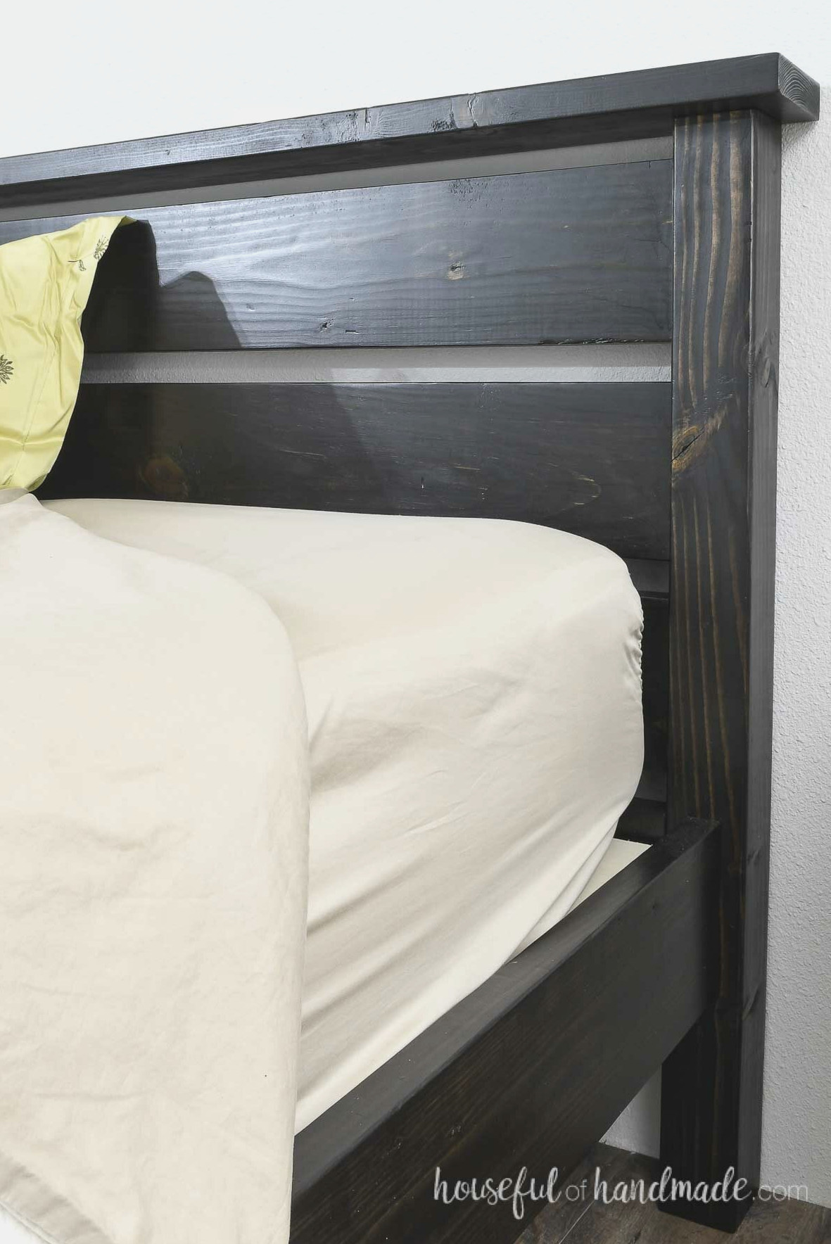 Close view of the DIY bed with the side rails positioned inward from the headboard edge. 