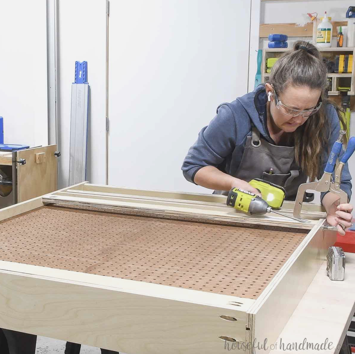 Attaching the french cleat to the back of the pegboard cabinet so there is space for the pegboard pieces. 