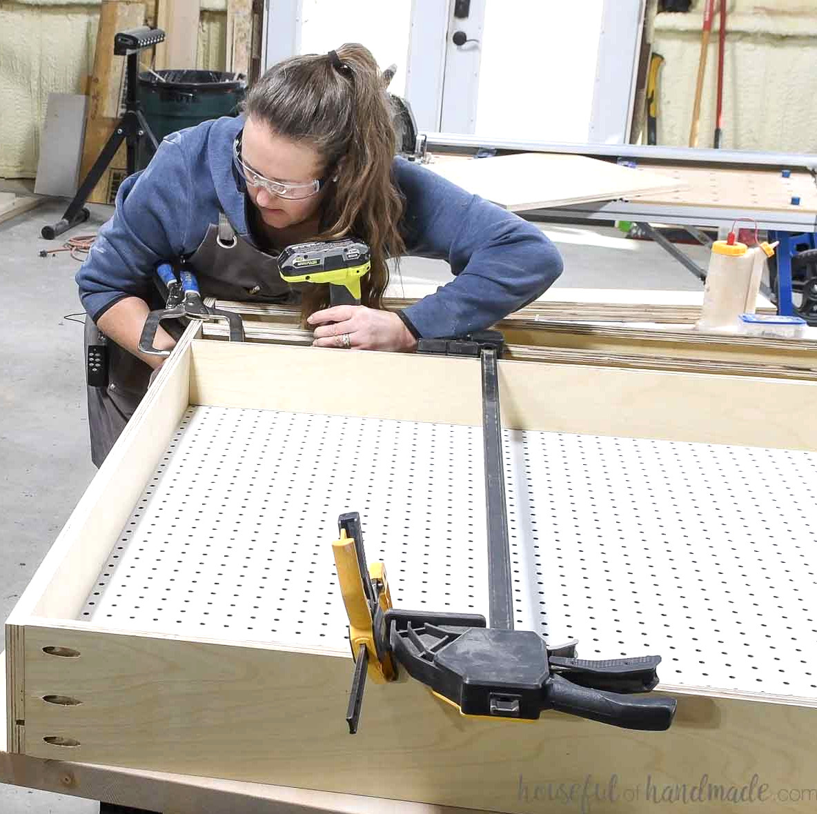 Securing the other side of the pegboard cabinet to enclose the pegboard. 