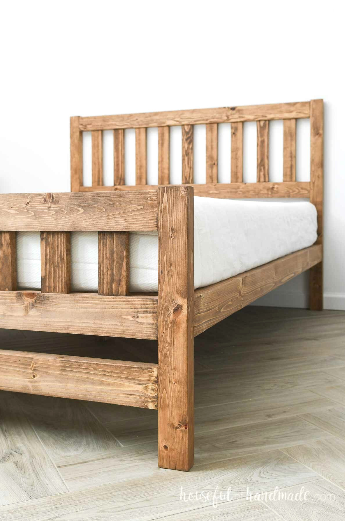 Close up of the footboard and side rails for the DIY platform bed with simple headboard design. 
