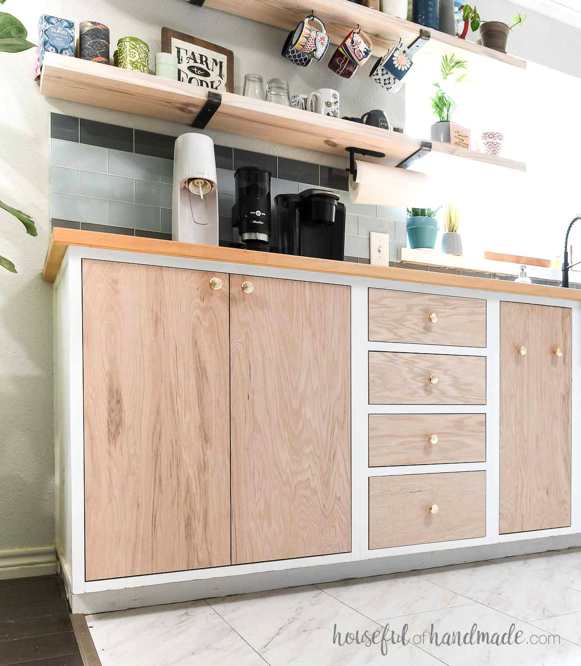 Slab kitchen cabinet doors from plywood inset into frameless white base cabinets.