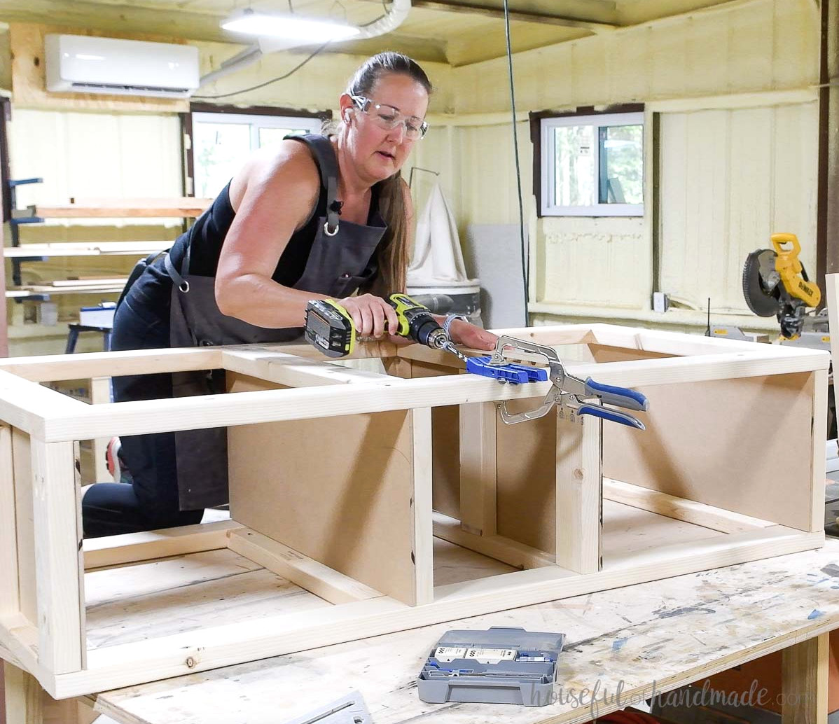 Drilling pocket holes in the front of the platform base to attach the face.