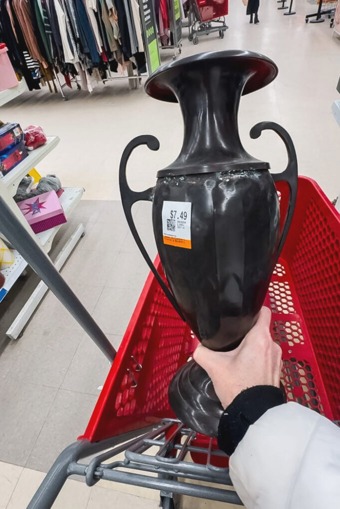 shopping in a thrift store and holding a metal urn