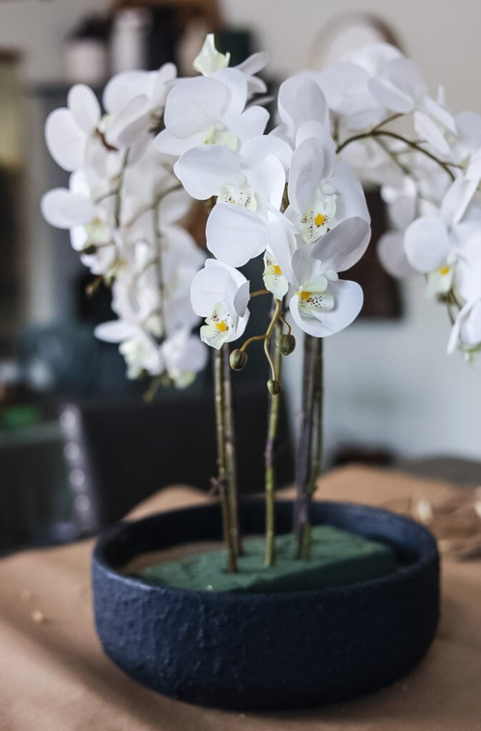an artificial orchid flower arrangement in the process of being made