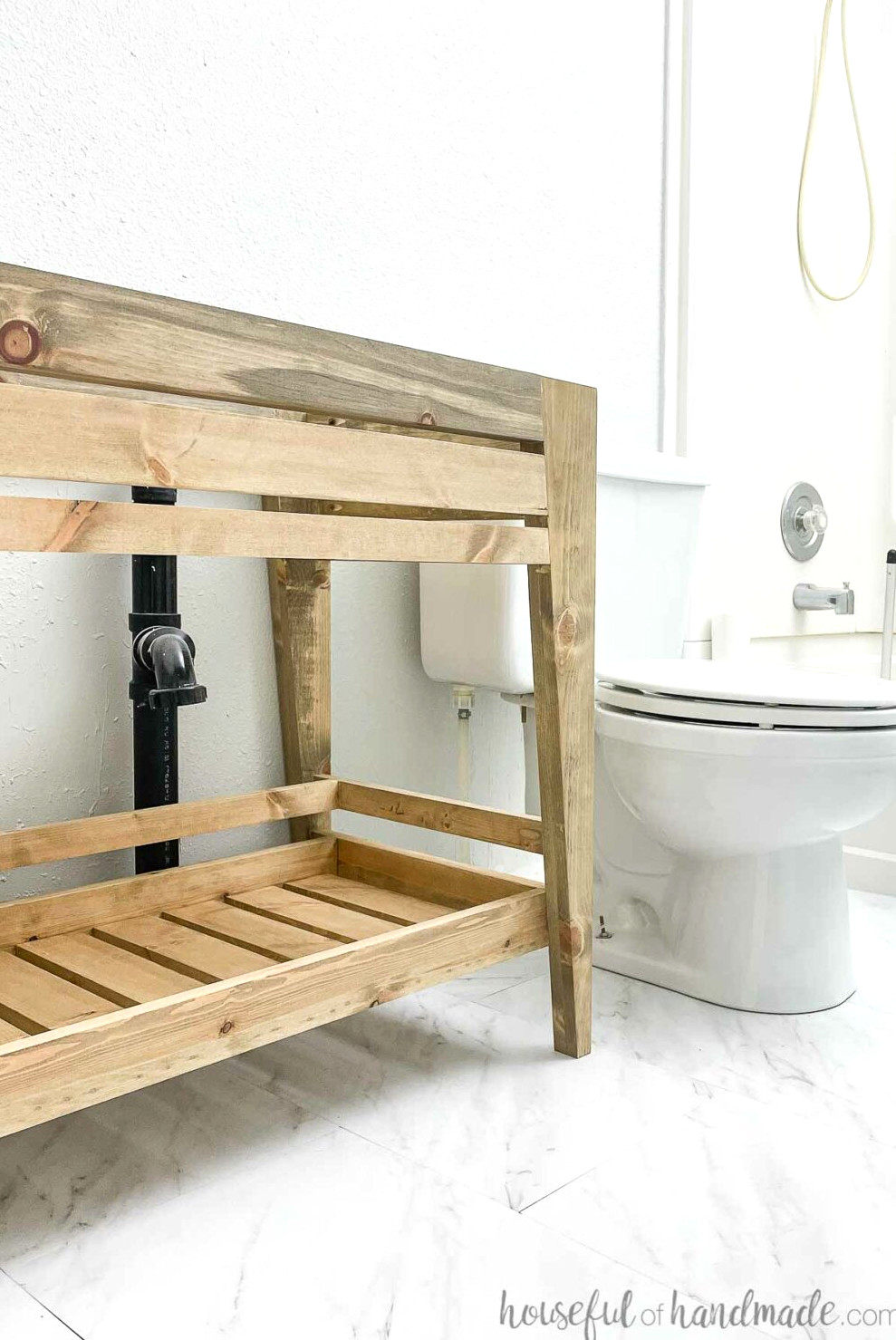 View into the compact bathroom featuring the installed DIY open-shelf bathroom vanity. 