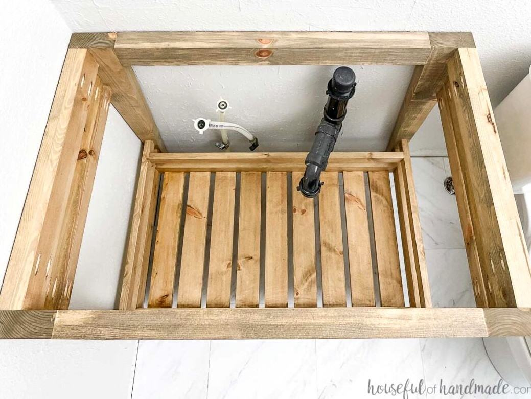 Overhead view of the open bathroom vanity featuring a lower shelf built from leftover wood. 